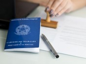 Mitarbeiterin der Ausländerbehörde stempelt einen ausländischen Pass. Informationen zum Aufenthaltsgesetz. Visum, Ausländeramt 