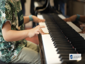 Das Bild zeigt ein Kind beim Tag der Musikschule 2023. Es probiert das Instrument Klavier aus.