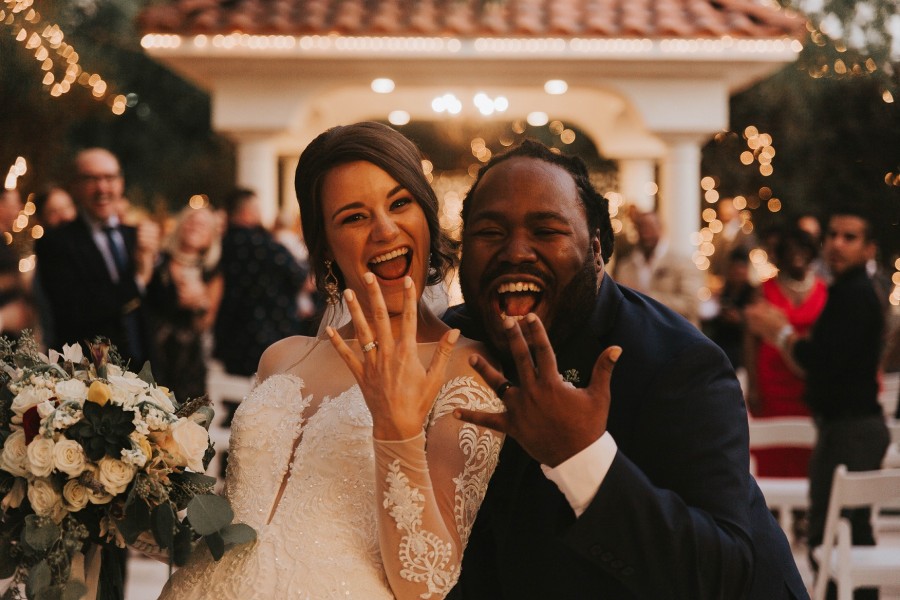 Frisch verheiratetes Ehepaar lacht in die Kamera, beide halten ihre Hände mit den Eheringen hoch. Hochzeit, Eheleute, Standesamt, Trauung - Photo by Analise Benevides on Unsplash Frisch verheiratetes Ehepaar lacht in die Kamera, beide halten ihre Hände mit den Eheringen hoch. Hochzeit, Eheleute, Standesamt, Trauung - Photo by Analise Benevides on Unsplash